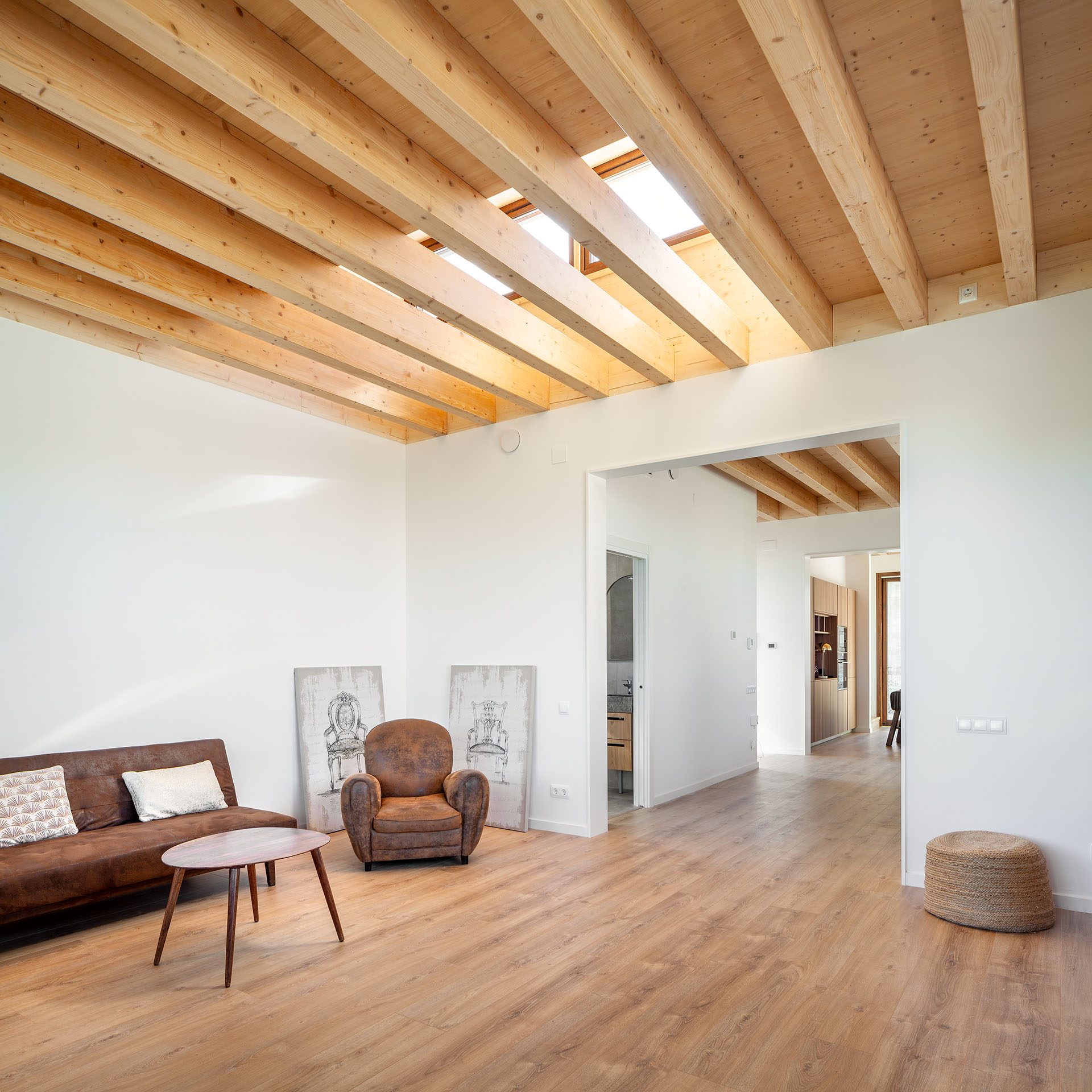 Interior d'un habitatge passiu de PAPIK Group amb sostre de bigues de fusta